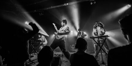 Concert de rock avec éclairage intense et musiciens.