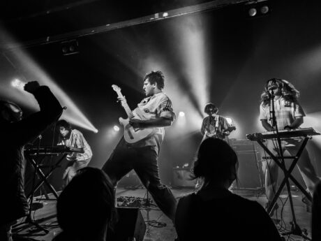 Concert de rock avec éclairage intense et musiciens.