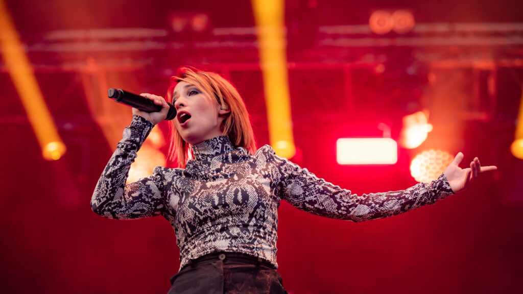 Chanteuse sur scène avec micro et éclairage rouge