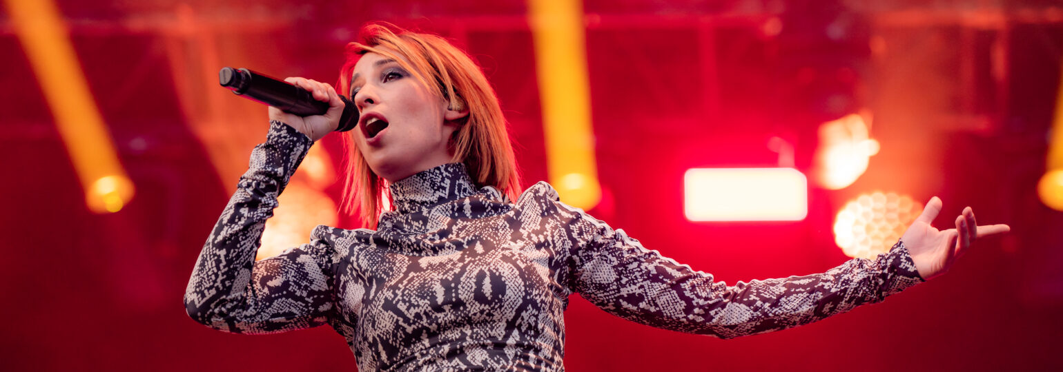 Chanteuse sur scène avec micro et éclairage rouge