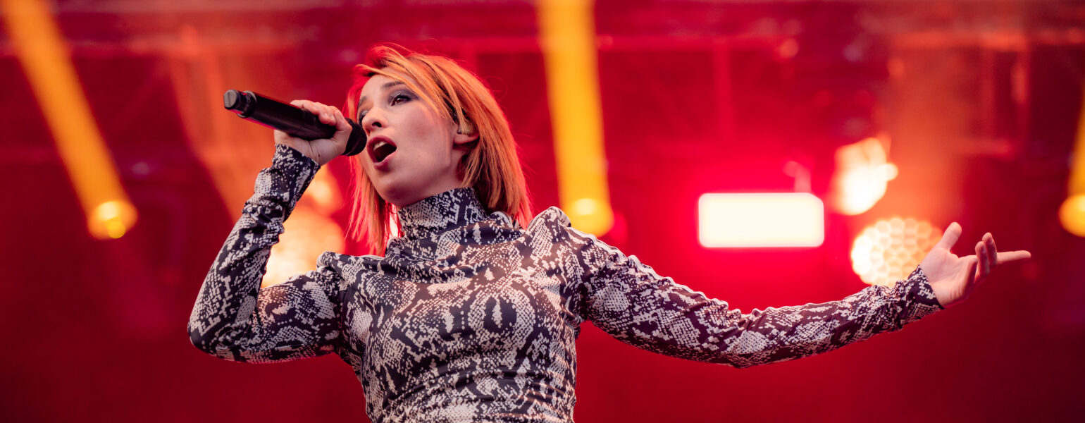 Chanteuse sur scène avec micro et éclairage rouge
