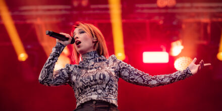 Chanteuse sur scène avec micro et éclairage rouge