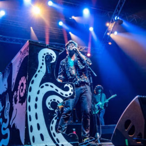 Groupe jouant en concert avec éclairage vibrant.