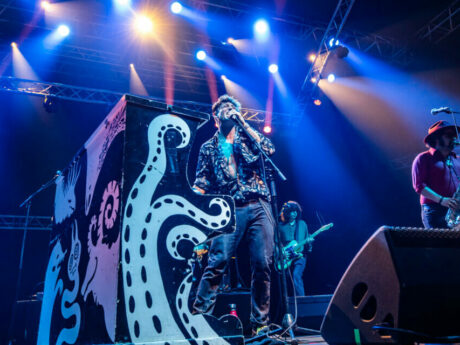 Groupe jouant en concert avec éclairage vibrant.