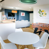 Salon moderne avec baby-foot et décoration colorée.