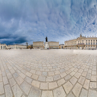 Panorama de la place avec statue et bâtiments historiques.