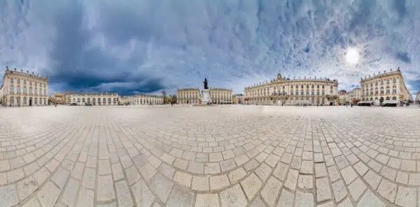 Panorama de la place avec statue et bâtiments historiques.