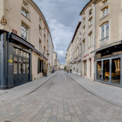 Rue avec bâtiments historiques et magasins.