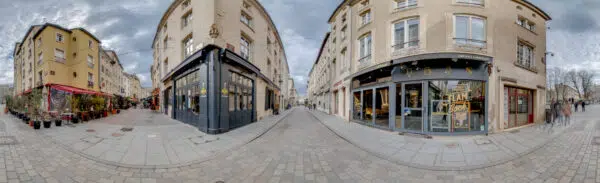 Rue avec bâtiments historiques et magasins.