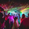 Personnes dansant sous des lumières colorées.