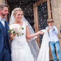 Mariage avec mariés souriants et pluie de confettis.