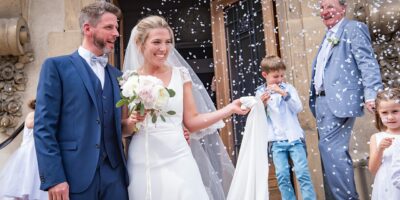 Mariage avec mariés souriants et pluie de confettis.