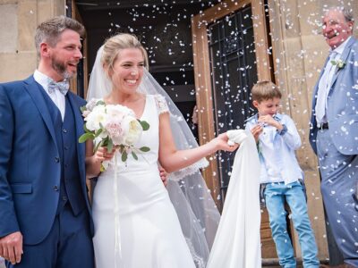 Mariage avec mariés souriants et pluie de confettis.