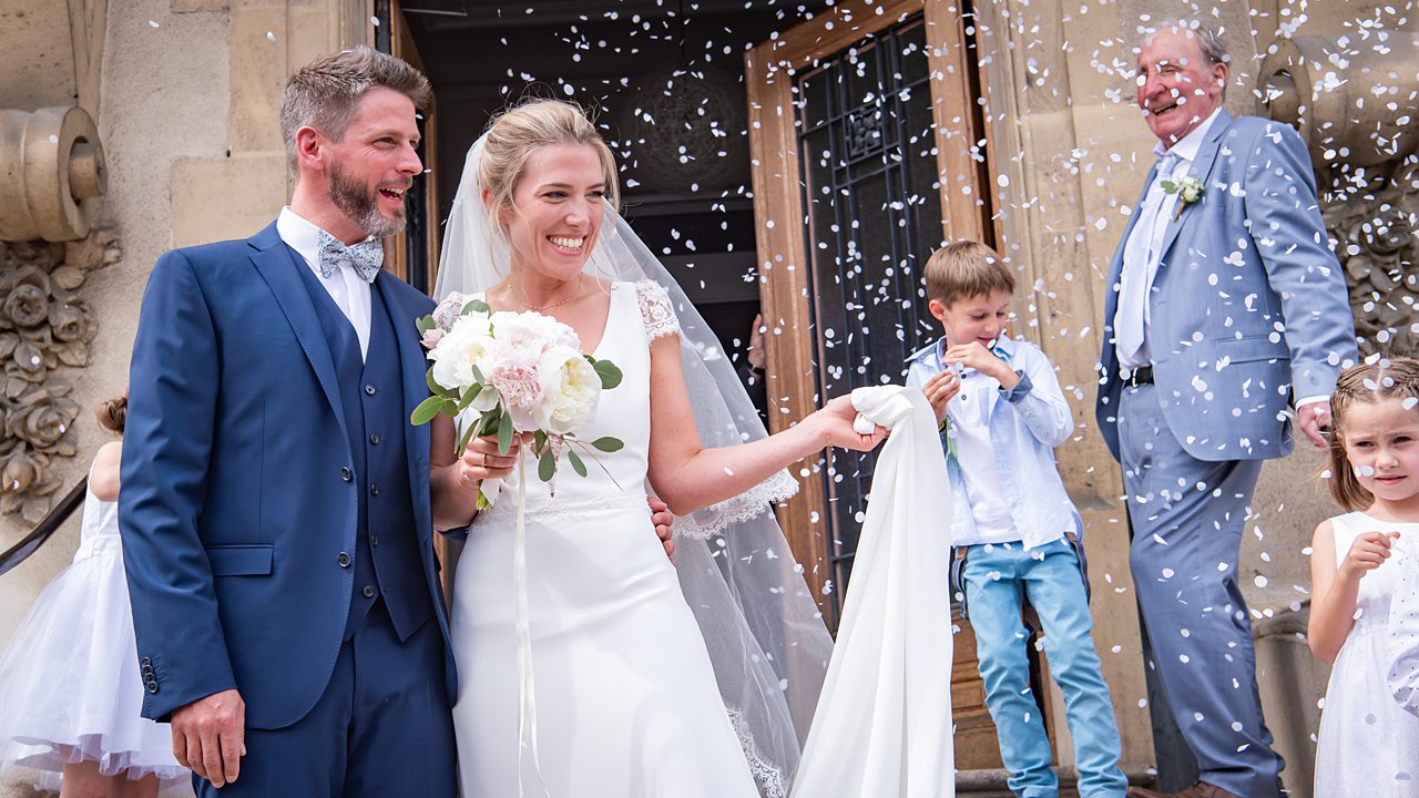 Mariage avec mariés souriants et pluie de confettis.