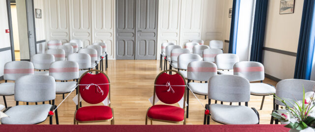 Salle des mariages d'une mairie avec chaises alignées