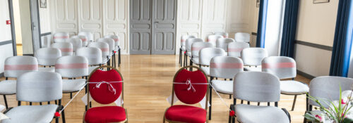 Salle des mariages d'une mairie avec chaises alignées