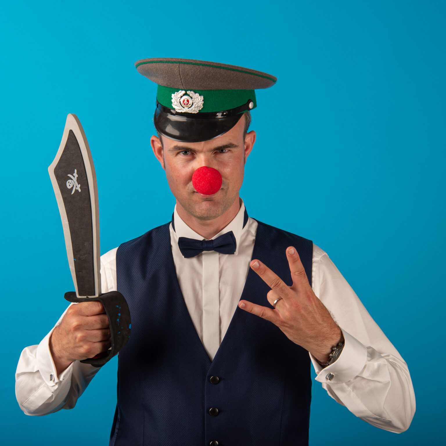 Homme déguisé avec nez rouge et épée en carton.