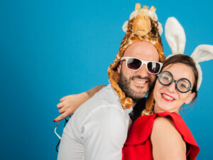 Deux personnes déguisées souriant devant un fond bleu.
