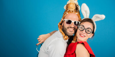 Deux personnes déguisées souriant devant un fond bleu.