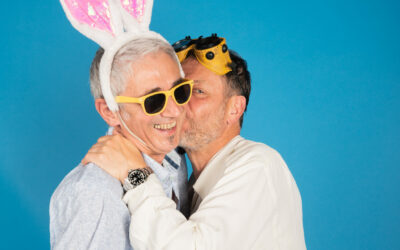 Deux hommes souriants avec accessoires amusants.