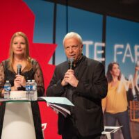 Deux personnes parlant lors d'un événement.