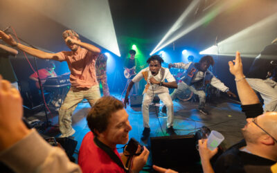 Concert avec énergie sur scène et public enthousiaste.