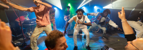 Concert avec énergie sur scène et public enthousiaste.