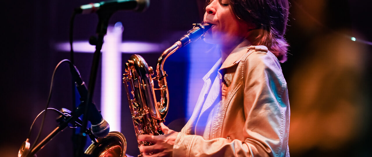 Musicien jouant du saxophone sur scène.