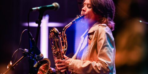 Musicien jouant du saxophone sur scène.