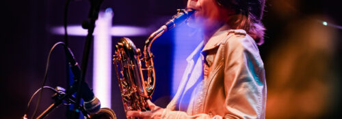 Musicien jouant du saxophone sur scène.