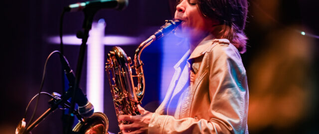 Musicien jouant du saxophone sur scène.