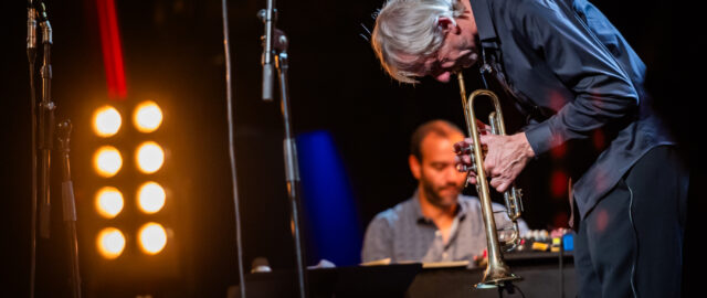 Musicien jouant de la trompette sur scène.