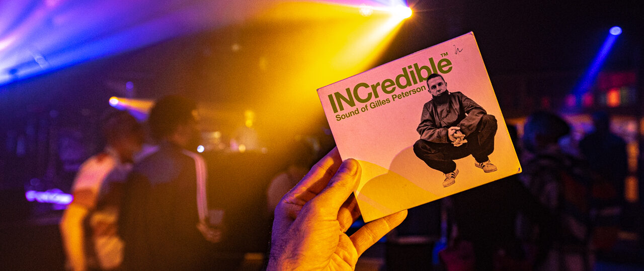 Main tenant un album dans un club lumineux.
