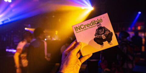 Main tenant un album dans un club lumineux.