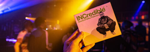 Main tenant un album dans un club lumineux.