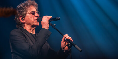 Chanteur sur scène avec un micro, ambiance de concert.