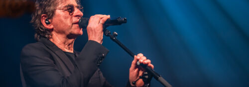 Chanteur sur scène avec un micro, ambiance de concert.