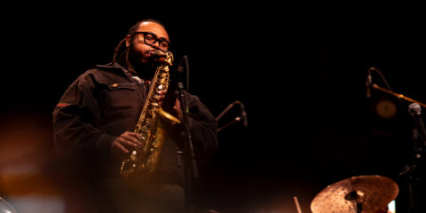 Musicien jouant du saxophone sur scène.