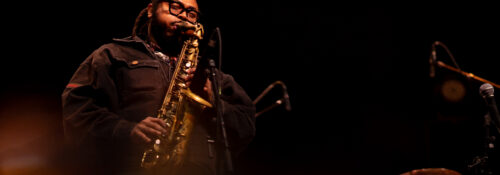 Musicien jouant du saxophone sur scène.