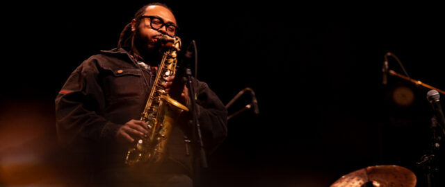 Musicien jouant du saxophone sur scène.