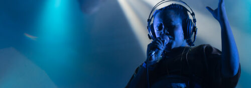 Chanteuse sur scène avec micro et écouteurs.