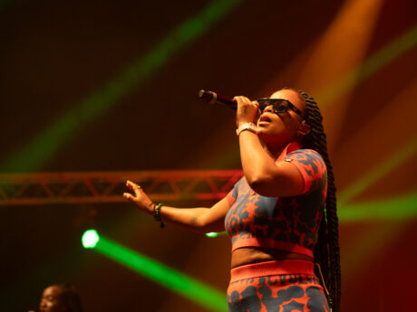 Chanteuse en concert avec micro et lunettes.