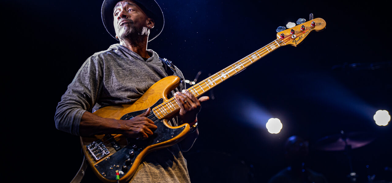 Musicien jouant de la basse sur scène.