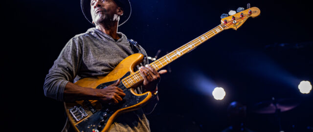 Musicien jouant de la basse sur scène.