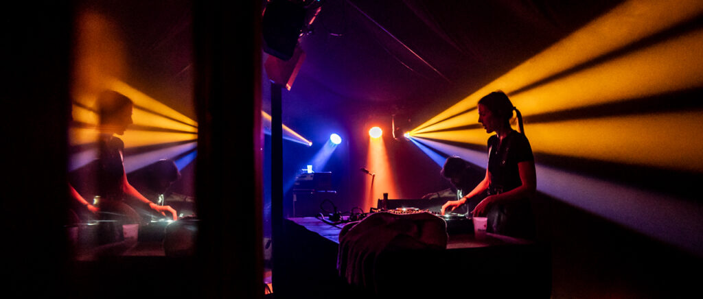 DJ joue dans une ambiance lumineuse colorée.