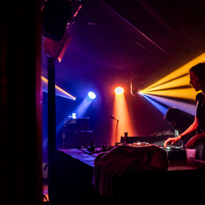 DJ joue dans une ambiance lumineuse colorée.