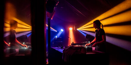 DJ joue dans une ambiance lumineuse colorée.