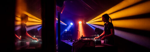 DJ joue dans une ambiance lumineuse colorée.