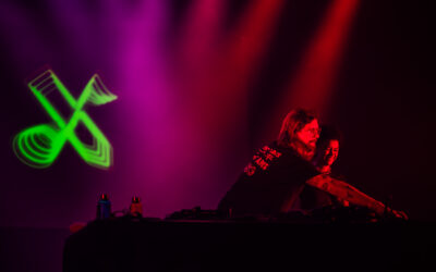 Deux personnes DJ mixant sur scène.