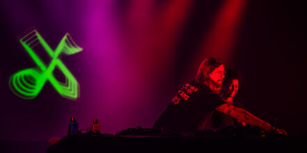 Deux personnes DJ mixant sur scène.
